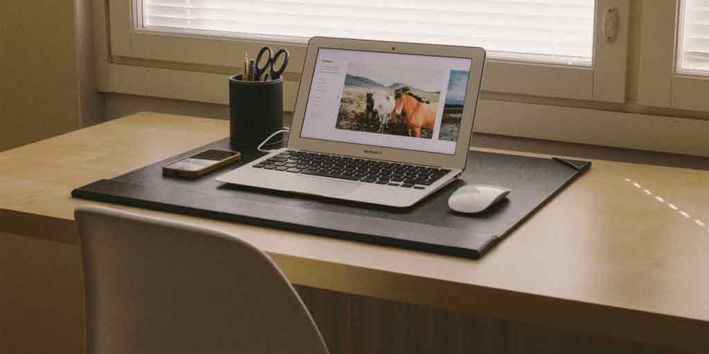 Laptop on a tidy desk beside a window