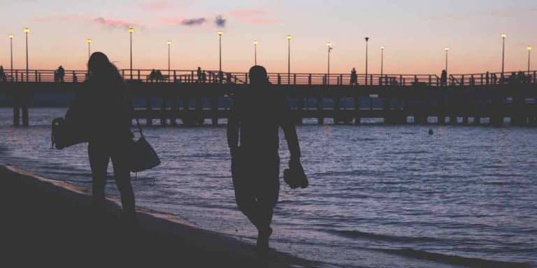 backdrop of sunset beach and two people walking