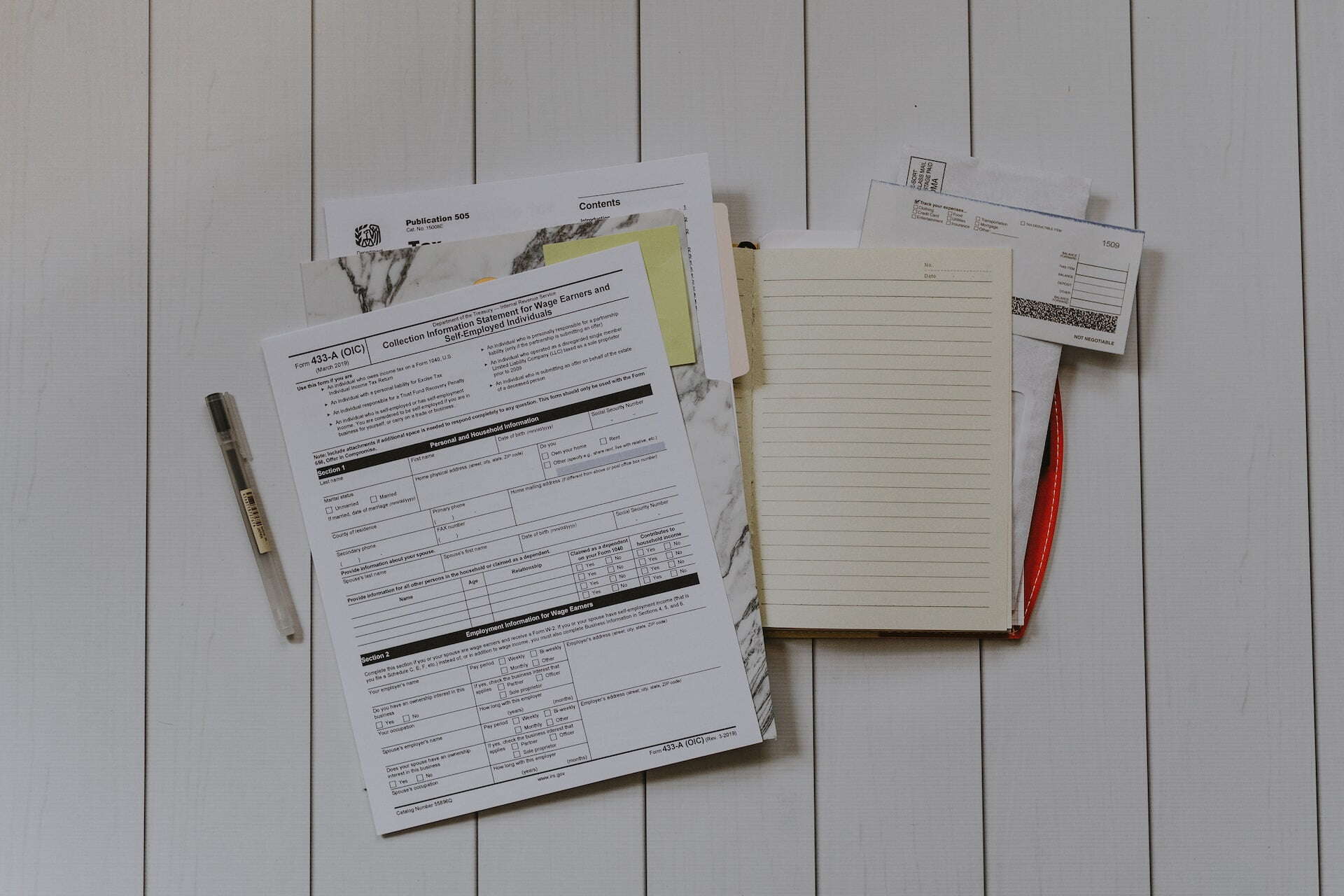 federal documents and files laid out on a table with a pen 