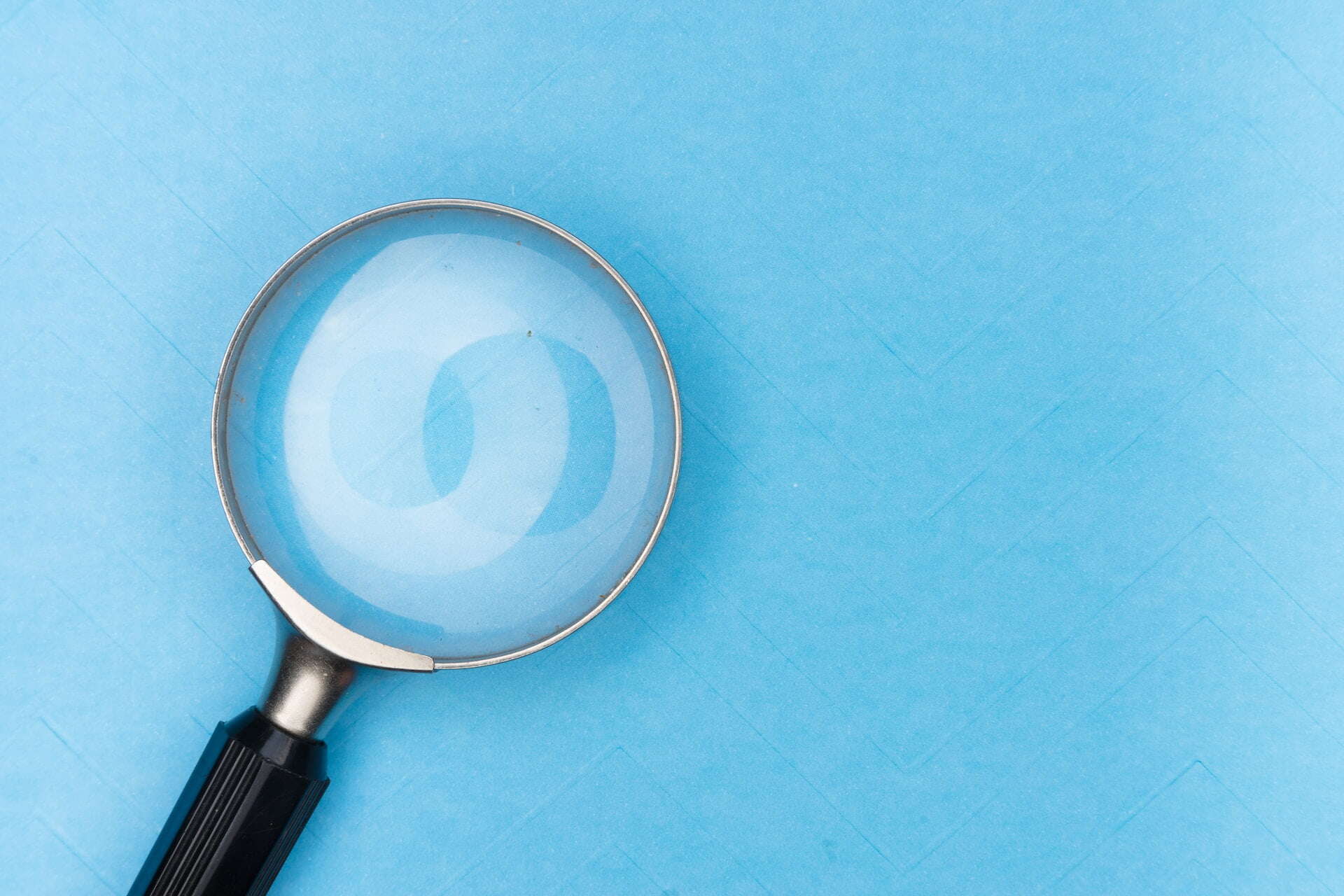 magnifying glass in front of a light blue background
