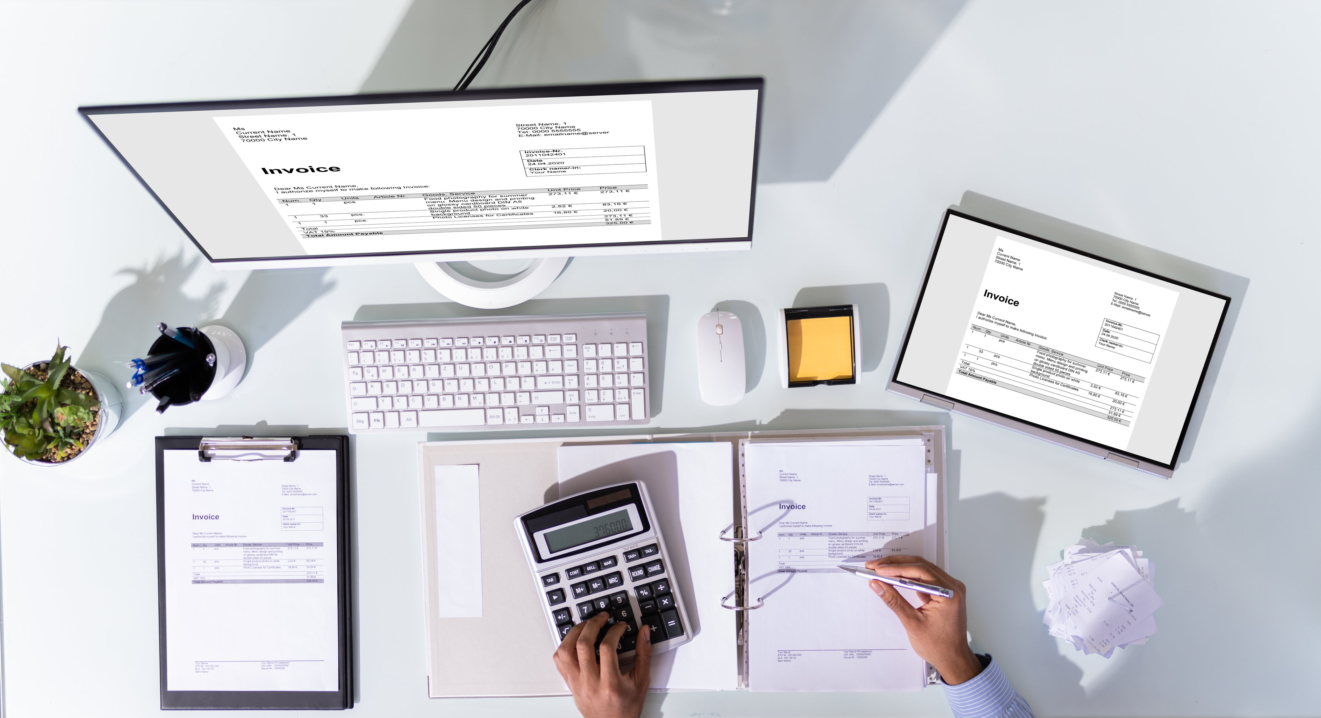 Bookkeeper working with invoices, calculator, and laptop—illustrating professional small business bookkeeping services in Santa Barbara.