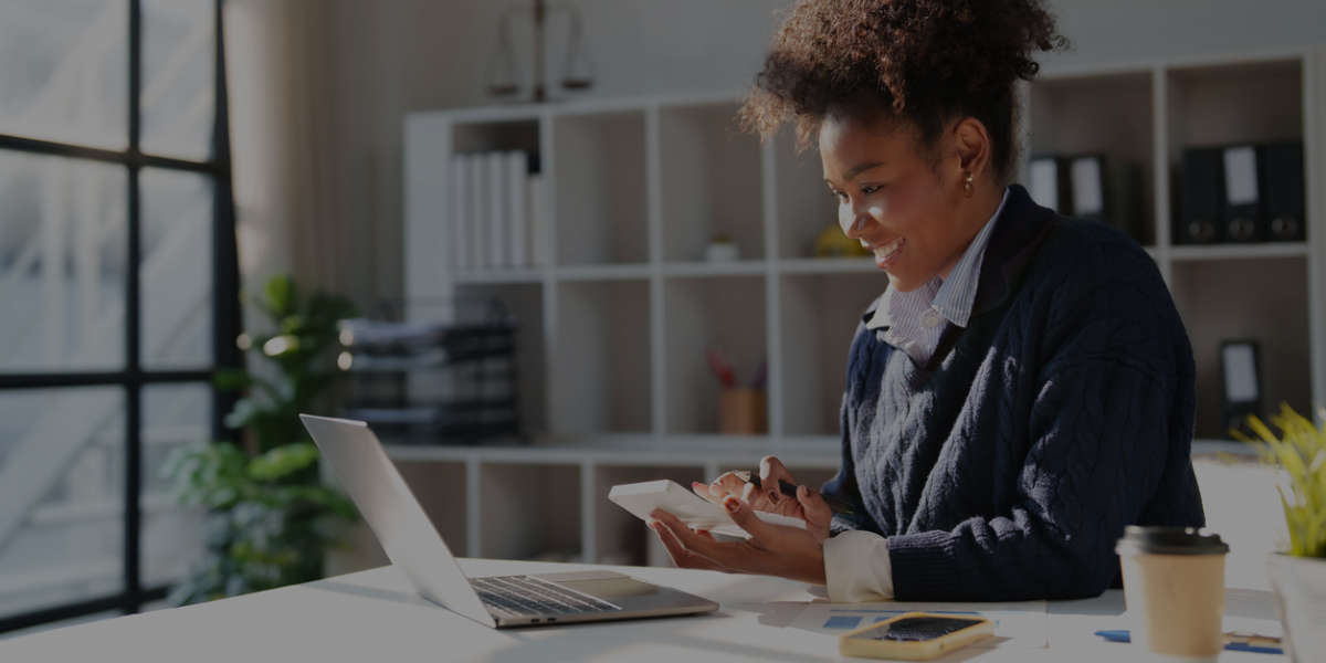 Financial professional using a calculator to build a 13-week cash flow forecast on a laptop.