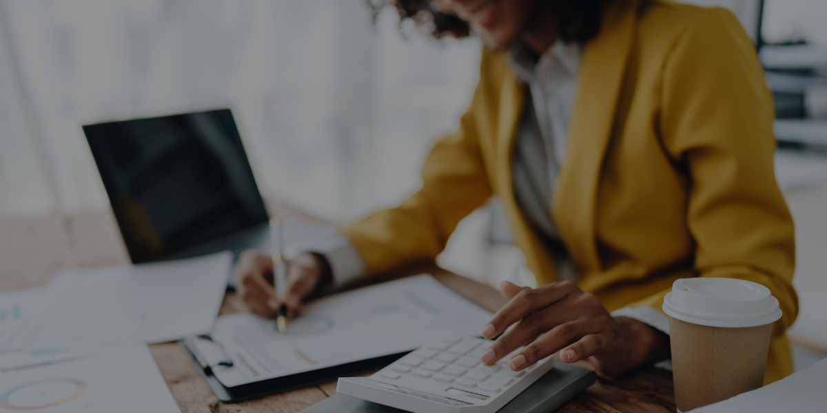 Financial professional reviewing charts and using a calculator—representing outsourced accounting services for small businesses.