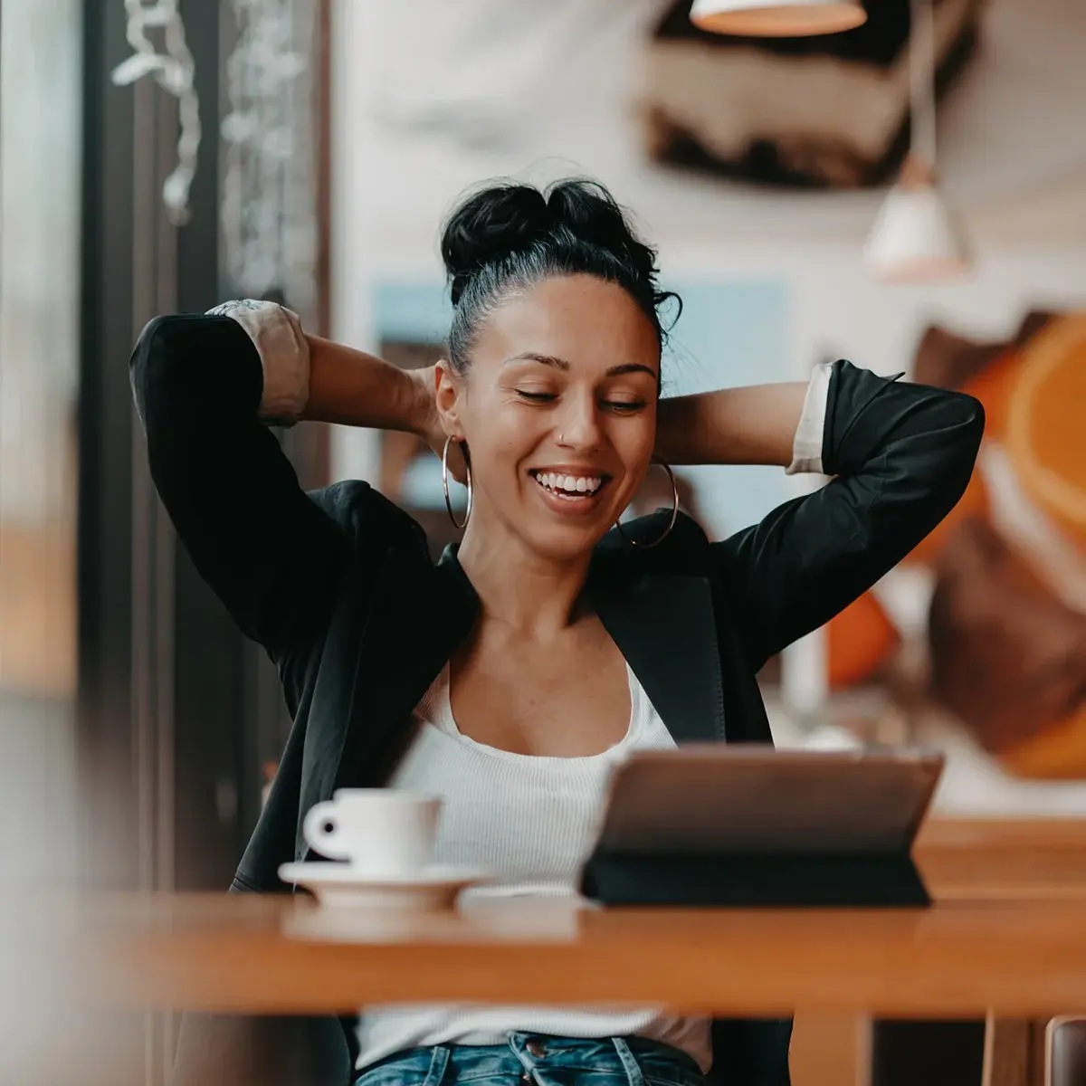 Relaxed business owner smiling at a tablet after hiring Accountix outsourced accounting.