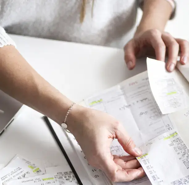 Hands organizing receipts and records, highlighting our scalable outsourced accounting for Montecito businesses.