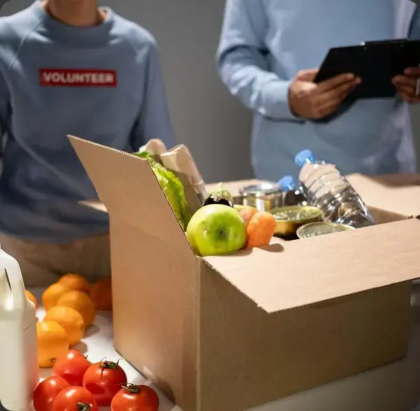 Volunteers packing a food donation box, representing the nonprofits Accountix serves.