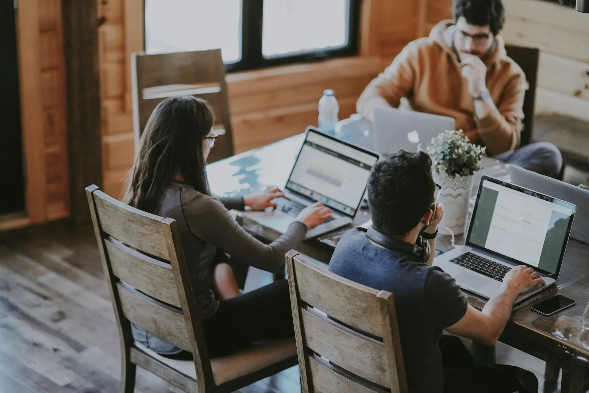 A team of professionals collaborating on laptops to gain financial clarity and maximize utilization.