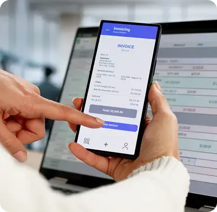 Hands using a mobile invoicing app synced to financial systems to eliminate manual data entry.