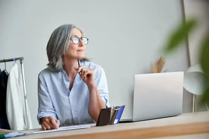 Business owner at her desk with a laptop, weighing whether her growing company needs a fractional CFO.