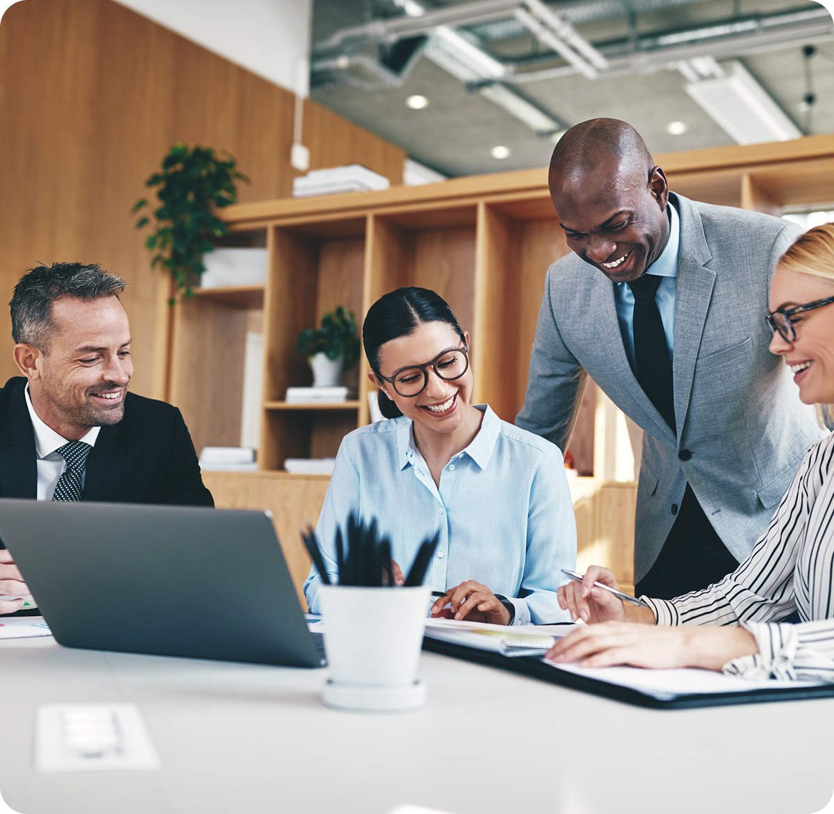 Accountix team of financial experts collaborating happily over a laptop and documents.