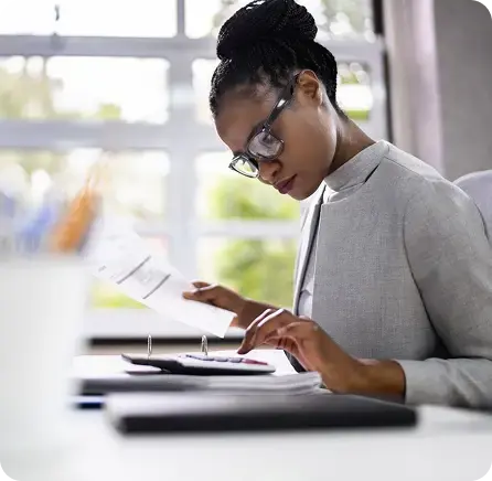Woman reviewing documents to protect the bottom line with faster, more accurate financial operations.