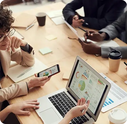 A team collaborating over real-time KPI dashboards and financial insights on a laptop.