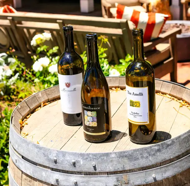 Los Olivos wine bottles on a barrel representing local tasting rooms using outsourced bookkeeping services