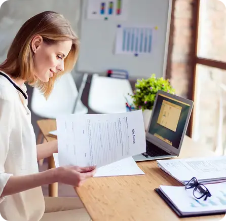 Smiling professional reviewing reliable, on-time monthly performance reports and variance analysis.