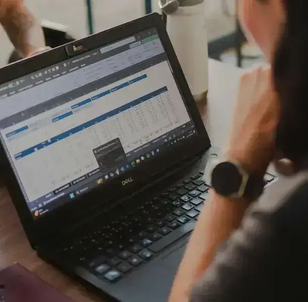 Professional reviewing a complex spreadsheet to track firm performance, utilization, and project profitability.