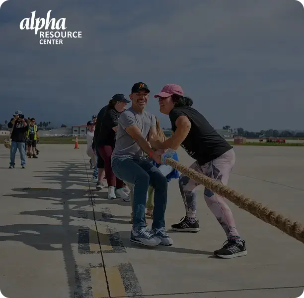 Alpha Resource Center supporters participating in a tug-of-war fundraiser event.
