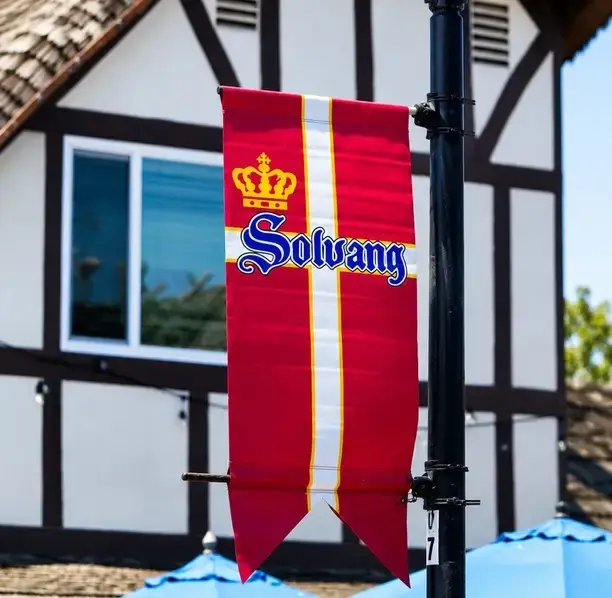A red Solvang street banner, highlighting our reliable bookkeeping services for local businesses.