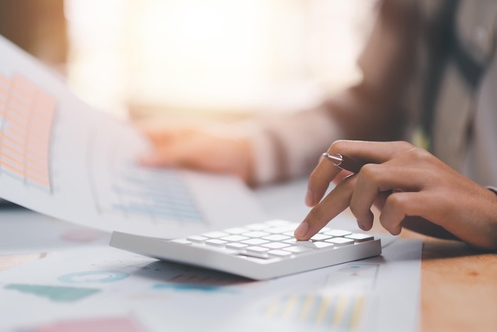 Reviewing nonprofit budget reports with a calculator and financial charts.