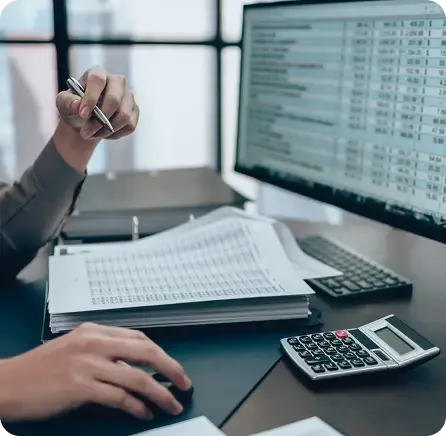 Accountant carefully reviewing printed financial reports and digital spreadsheets to ensure accurate books.